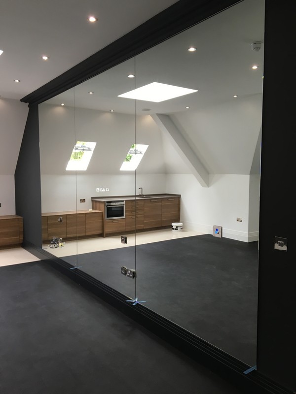 Frameless glass partition in loft conversion by West Brompton glaziers