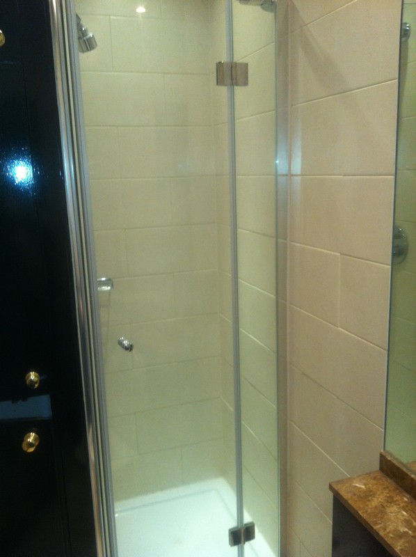 Frameless glass shower enclosure with chrome fittings in West Brompton